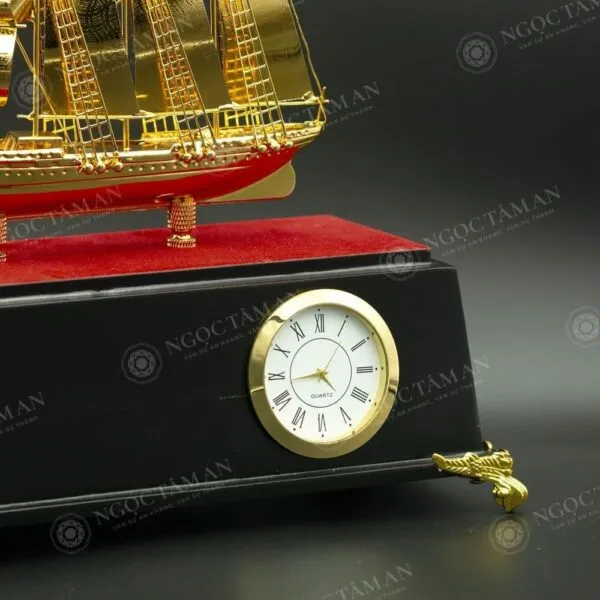 Cận cảnh đồng hồ Quartz viền vàng với số La Mã trên đế gỗ đen